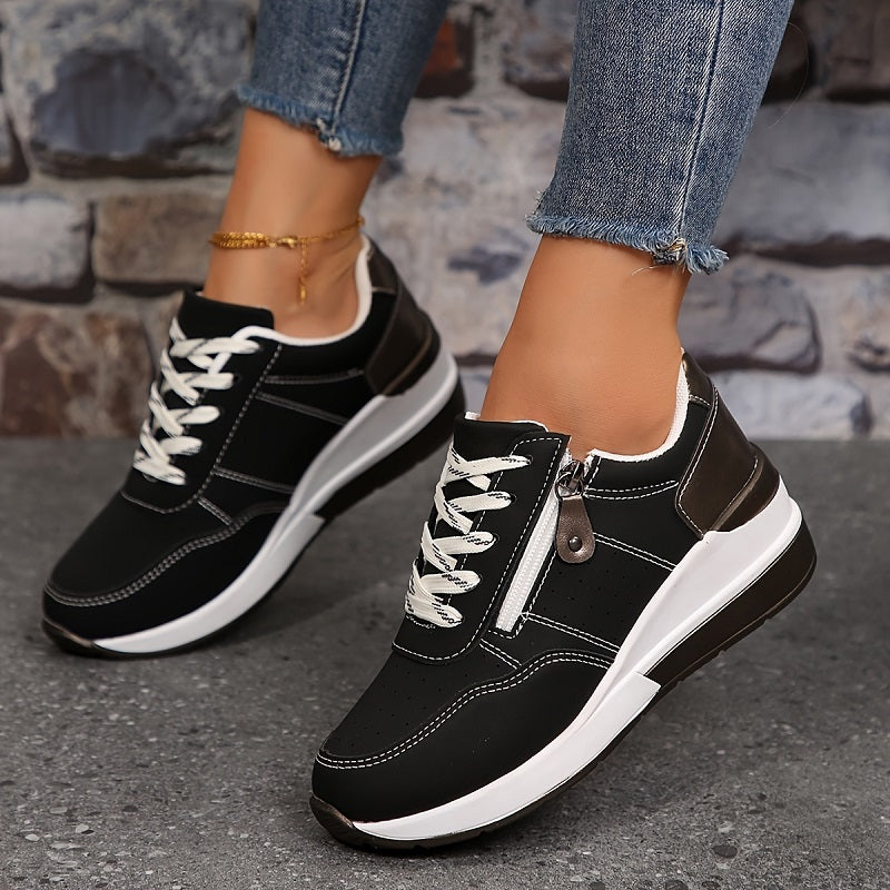 Fekete, fűzős női sneaker oldalcipzárral és vastag fehér talppal, lépés közben fotózva 4