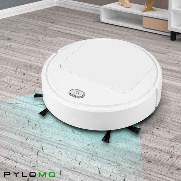 Fehér robotporszívó szürke fa hatású padlón, előtte kékes sávval jelölve a kefék által takarított terület. 3