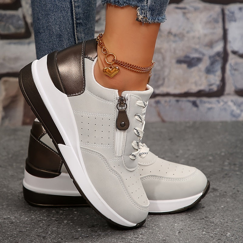 Világosszürke sneaker oldalnézetből, cipzárral, fémes sarokrésszel és szív alakú bokaláncos lábbal 3
