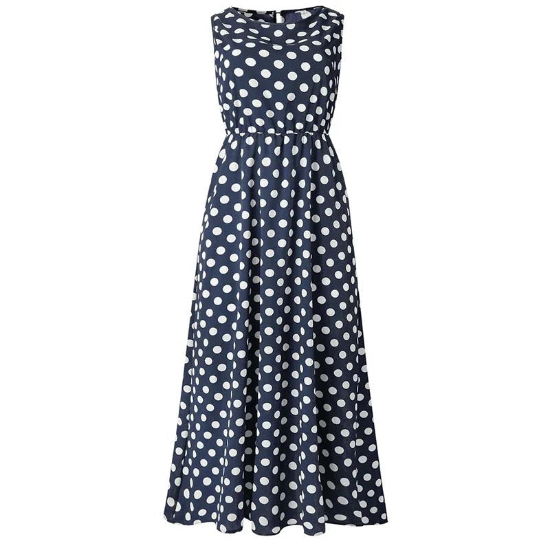 Sötétkék alapon fehér pöttyös, hosszú ujjatlan ruha elölről, gumis derékkal és bővülő szoknyával, kiterítve fehér háttéren. 6