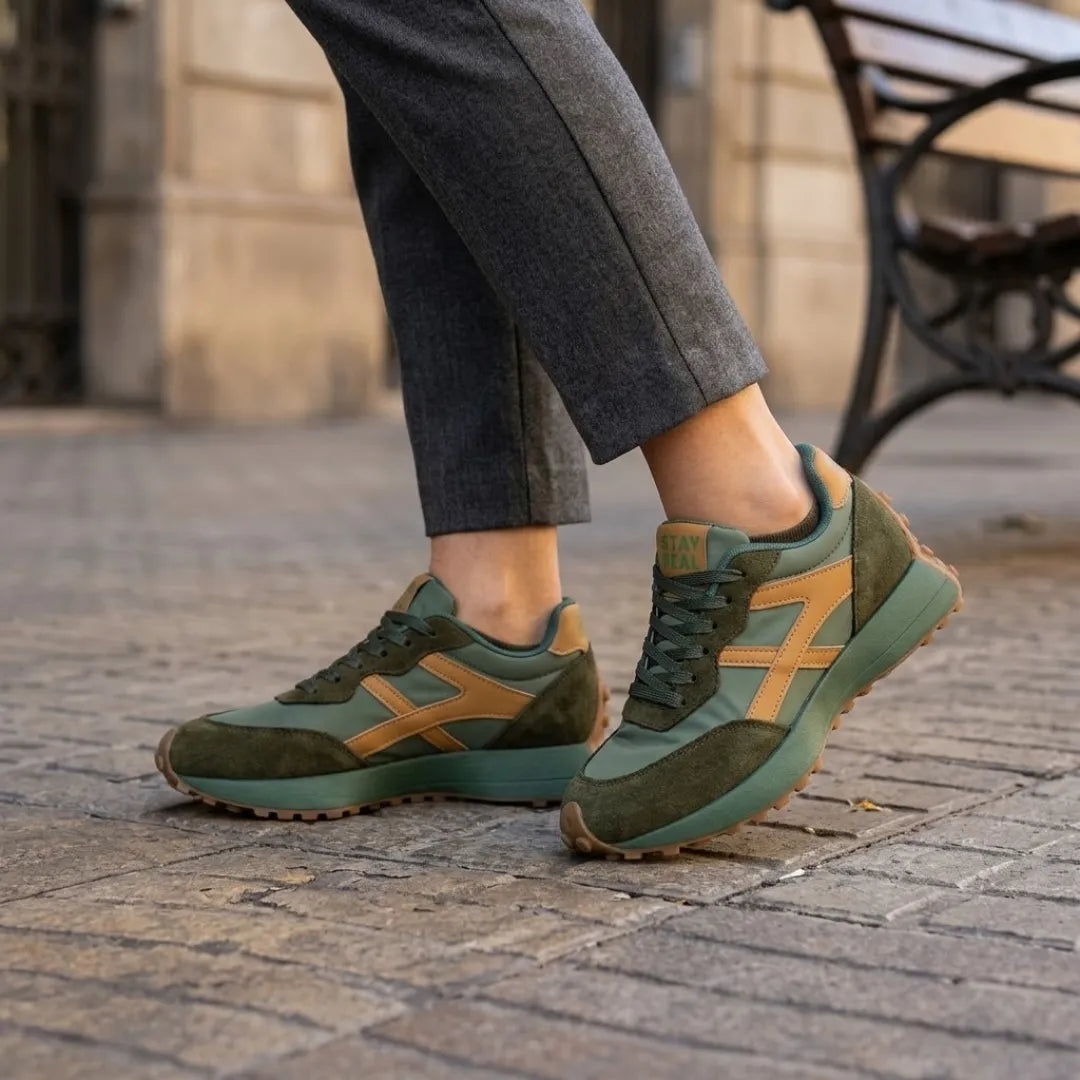Zöld sneaker lábon, szürke nadrággal kombinálva kockaköves utcán 12