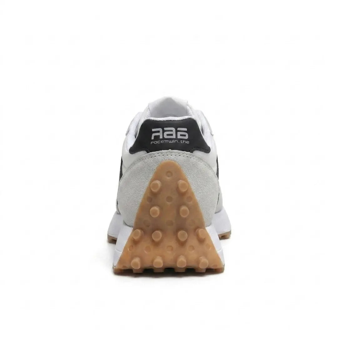 Sneaker hátulról, a fekete sarokrész és a háromszög alakú, bütykös barna talp hátsó része látható 25
