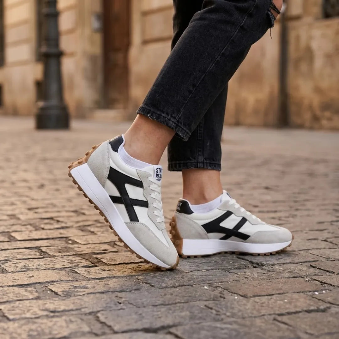 Modell lábán a sneaker kopott pincekövön, fekete farmerrel és fehér zoknival viselve 22