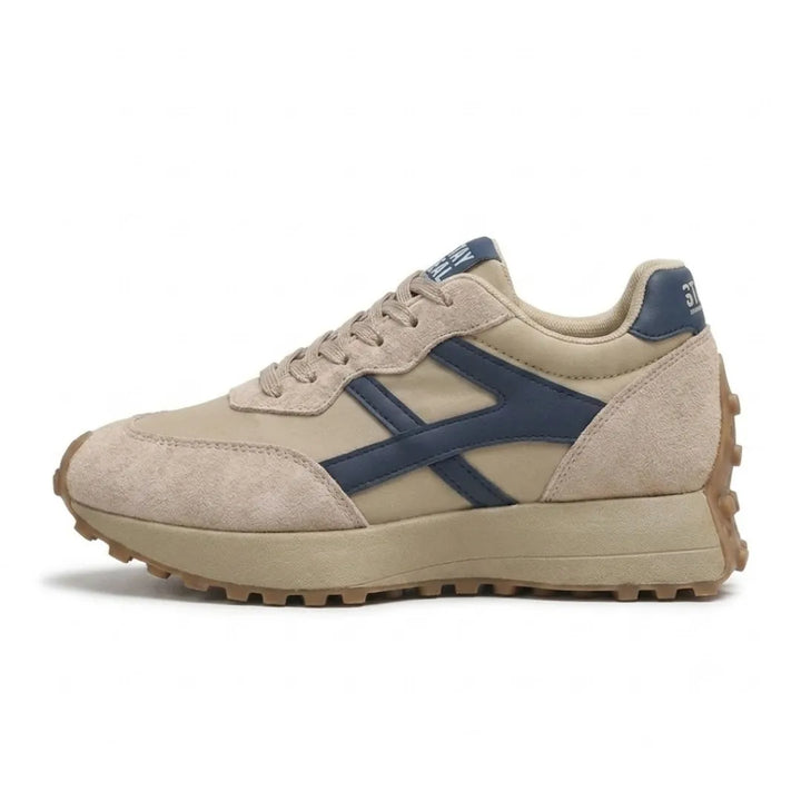 Bézs sneaker oldalnézetből, sötétkék oldalsó díszcsíkkal és vastag, bordázott gumitalppal 1