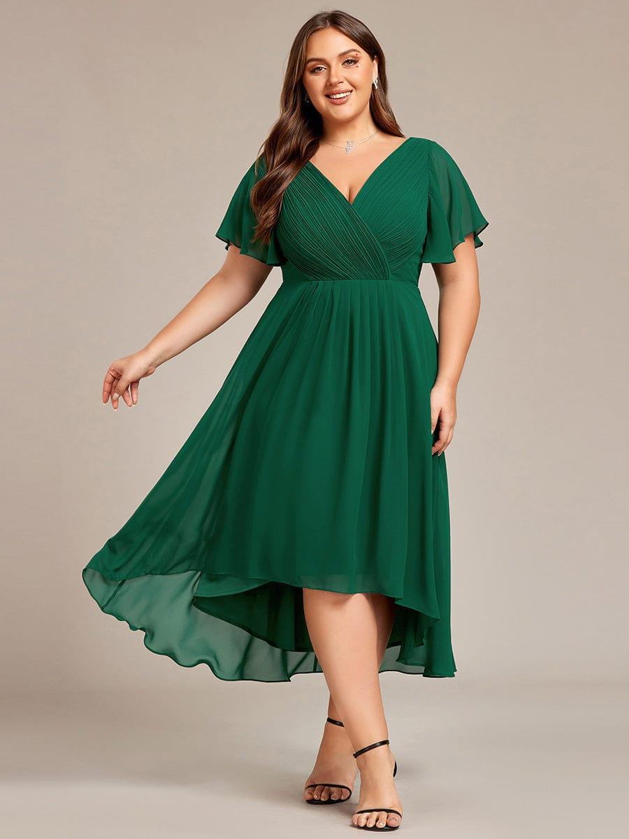 Sötétzöld ruha plus size modellen elölről, lengő, magas-alacsony szoknyával és fodros rövid ujjakkal. 36