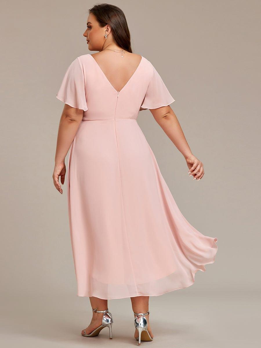 Rózsaszín ruha plus size modellen hátulról, mély V-hátkivágás, középső cipzár és lengő hátsó szegély. 32