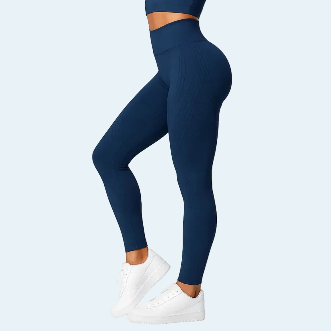 Sötétkék leggings oldalnézetből, fehér sportcipős modellen, a lábszáron és a combon finom bordázott szerkezettel. 4