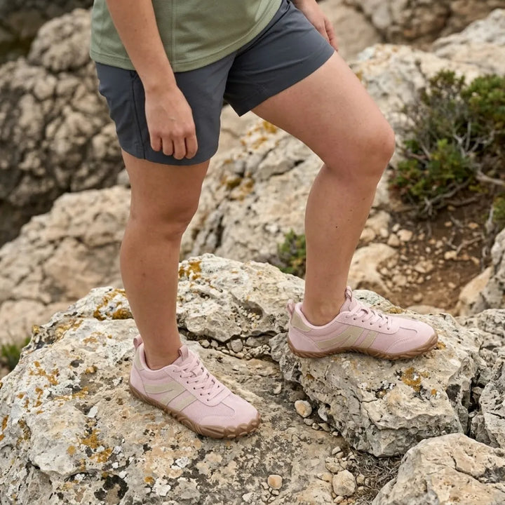Rózsaszín barefoot cipő viselés közben, rövidnadrágos lábakon, mohás sziklás terepen. 11