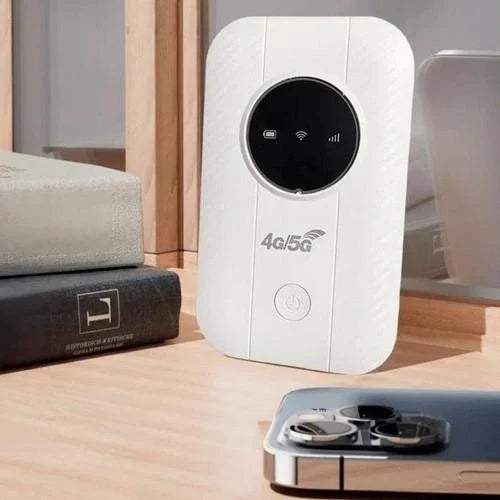 Fehér hordozható router áll egy asztalon könyvek és egy okostelefon mellett 3