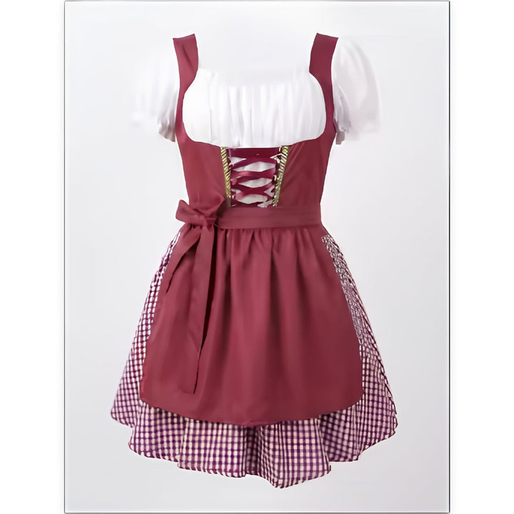 Bordó dirndl ruha elölnézetből, fehér puffos ujjú blúzzal, fűzős mellrésszel, masnis kötényrésszel és kockás alsószoknyával. 1