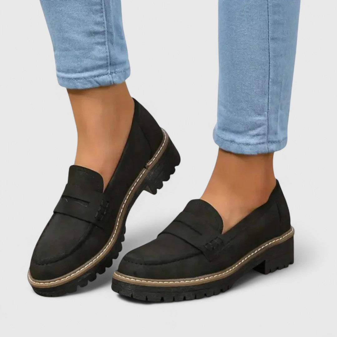 Fekete velúrhatású loafer, vastag bordázott talppal, világoskék farmerhez viselve, oldalnézetből 1