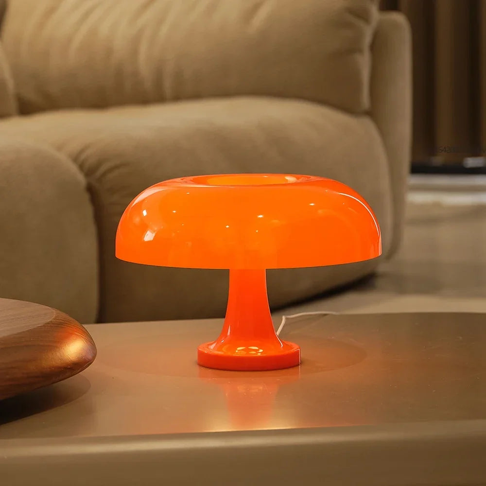 Narancssárga gombalámpa világít egy asztalon bézs kanapé előtt, a vezeték is látszik. 5