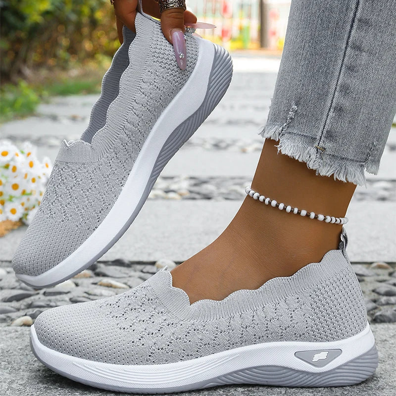 Világosszürke cipő pár, az egyik lábon, a másikat kéz tartja, látszik a belseje 10