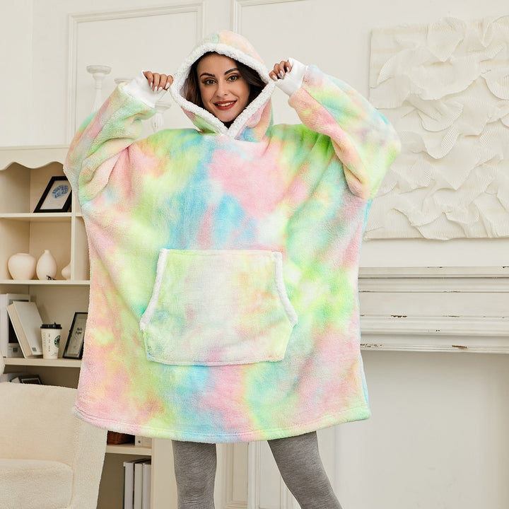 Frau in buntem, übergroßem Hoodie-Decke, Kapuze, gemütlich, Wohnzimmer, Mode, Freizeitkleidung.