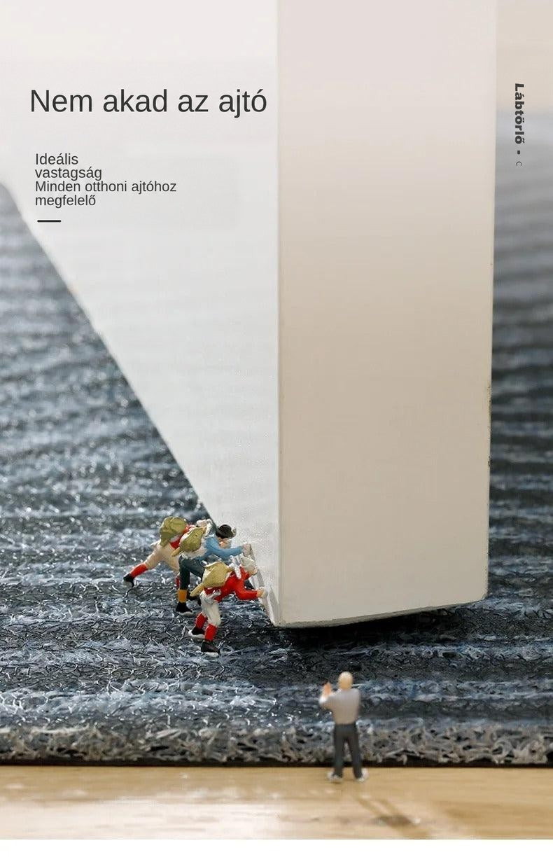 Lábtörlő szőrös felülete közelről, a fehér ajtó alsó élével, apró miniatűr figurákkal 10