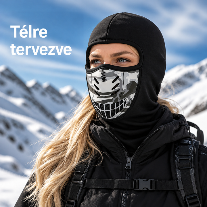 Szőke hajú nő havas hegyek előtt, fekete símaszkot visel, amelynek szájrészén szürke terepmintás szellőzős betét van. 1
