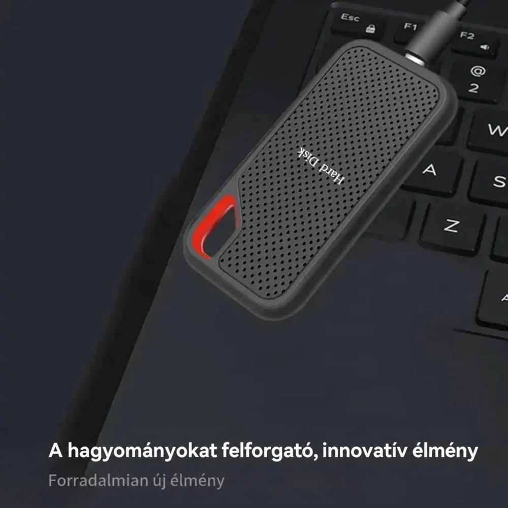 A hordozható SSD kábellel csatlakoztatva egy laptop billentyűzetén, sötét háttéren 2