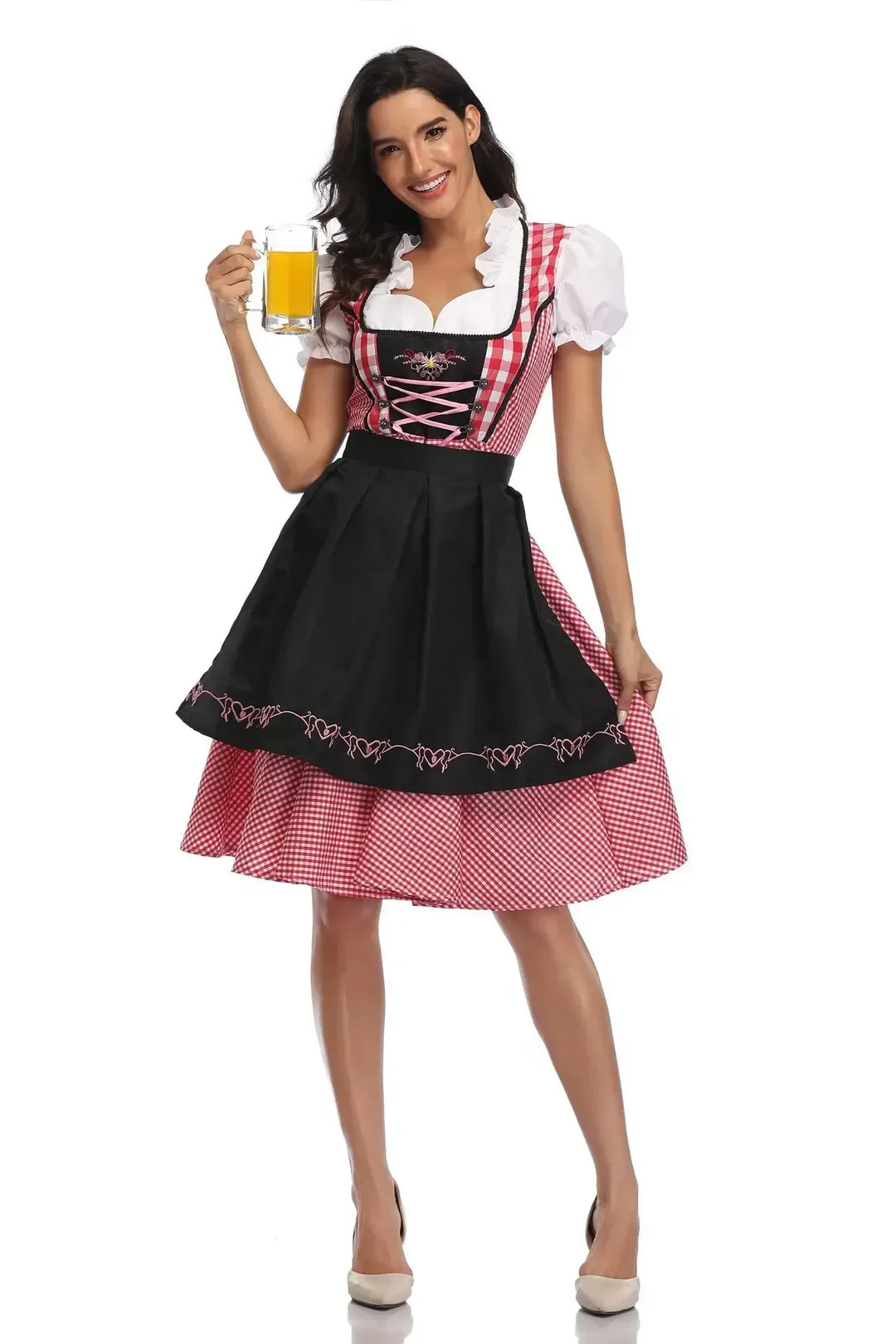 Fekete kötényes, piros kockás dirndl elölről, rózsaszín fűzővel és szív mintás hímzéssel, a modell sört tart. 9
