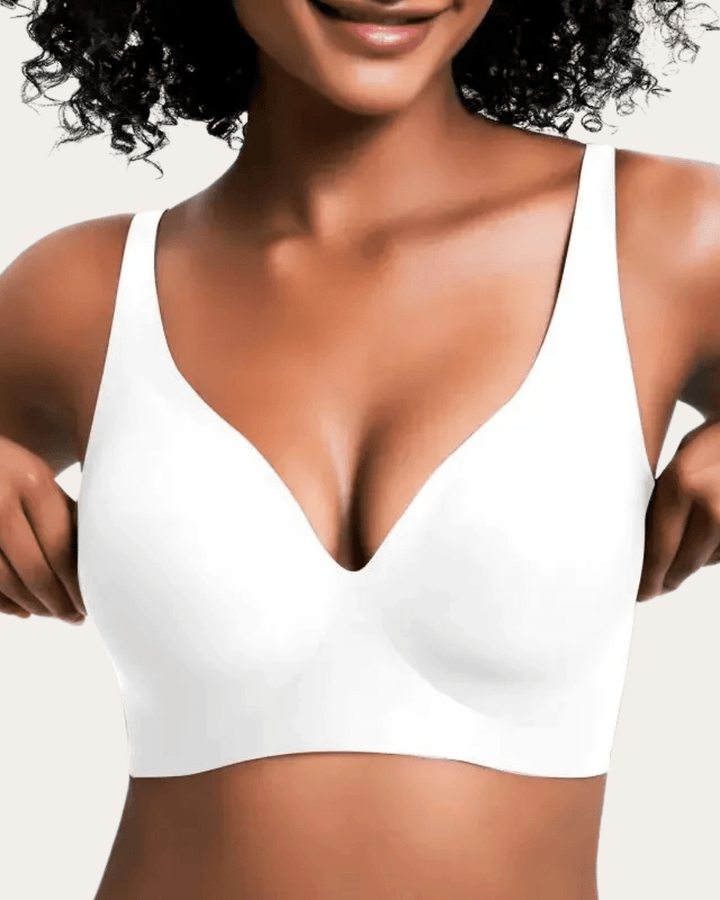 Modell fehér, sima, varrásmentes, mély V-nyakú melltartóban, elölnézetből. 7