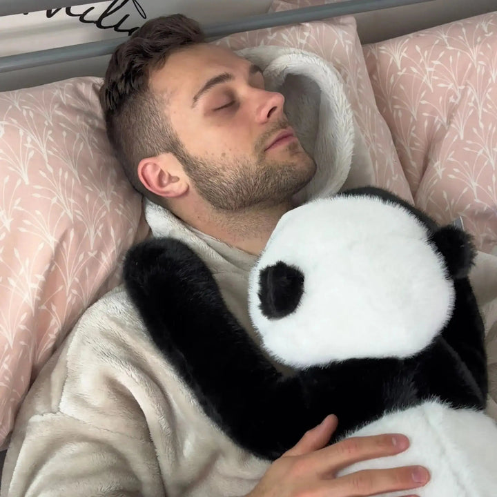 Alvó férfi ágyban, mellkasán a panda plüss pihen, hosszú fekete karjai a vállát ölelik. 11