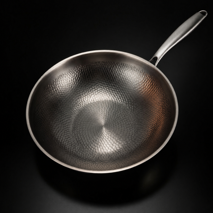 A wok felülnézetből, jól látszik a belső felület kalapált, pikkelyes mintázata és a hosszú nyél. 2