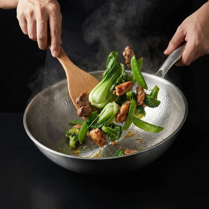 Két kéz kevergeti a wokban a bok choyt, brokkolit, cukorborsót és húsdarabokat fa spatulával. 7