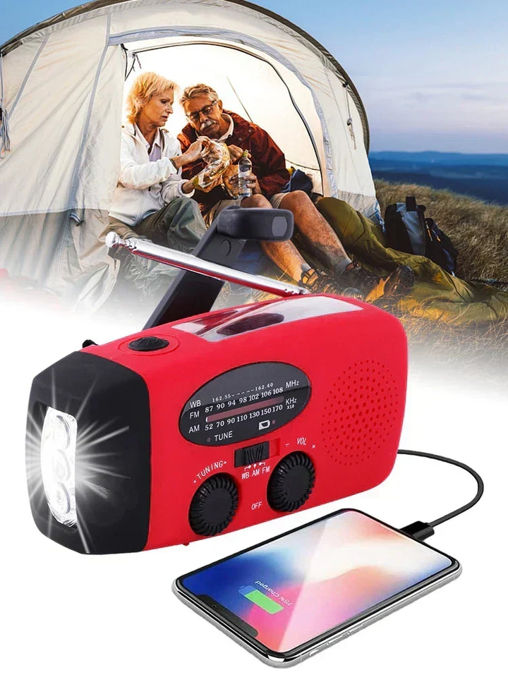 Táborozó idős pár a sátor bejáratánál, előtérben a világító lámpájú piros rádió tölt egy telefont 4
