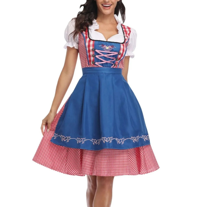 Elölnézet: piros kockás dirndl élénkkék köténnyel, rózsaszín fűzős mellrésszel és buggyos ujjú fehér blúzzal, modellen. 3