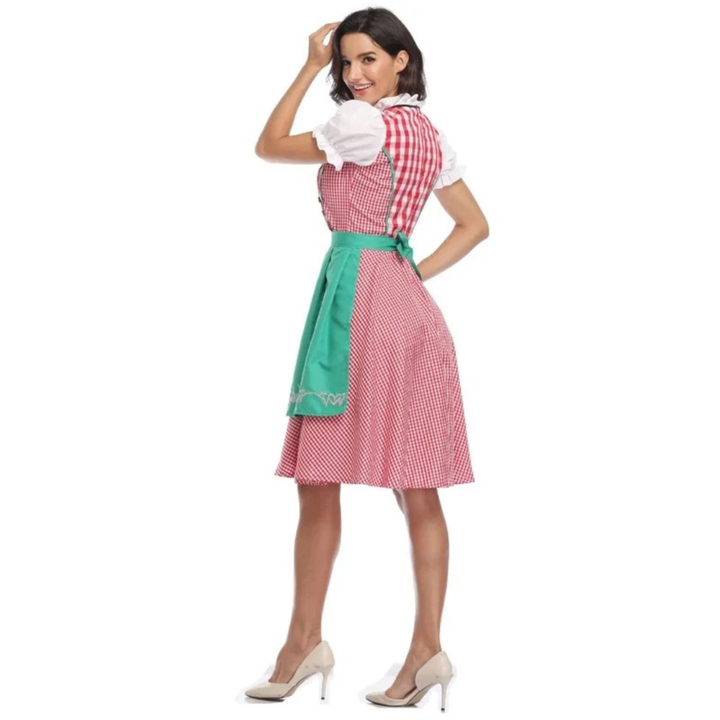 Hátulnézet: rózsaszín kockás dirndl zöld kötény masnijával és hímzett szegélyével, fehér buggyos ujjú blúzzal, modellen. 10