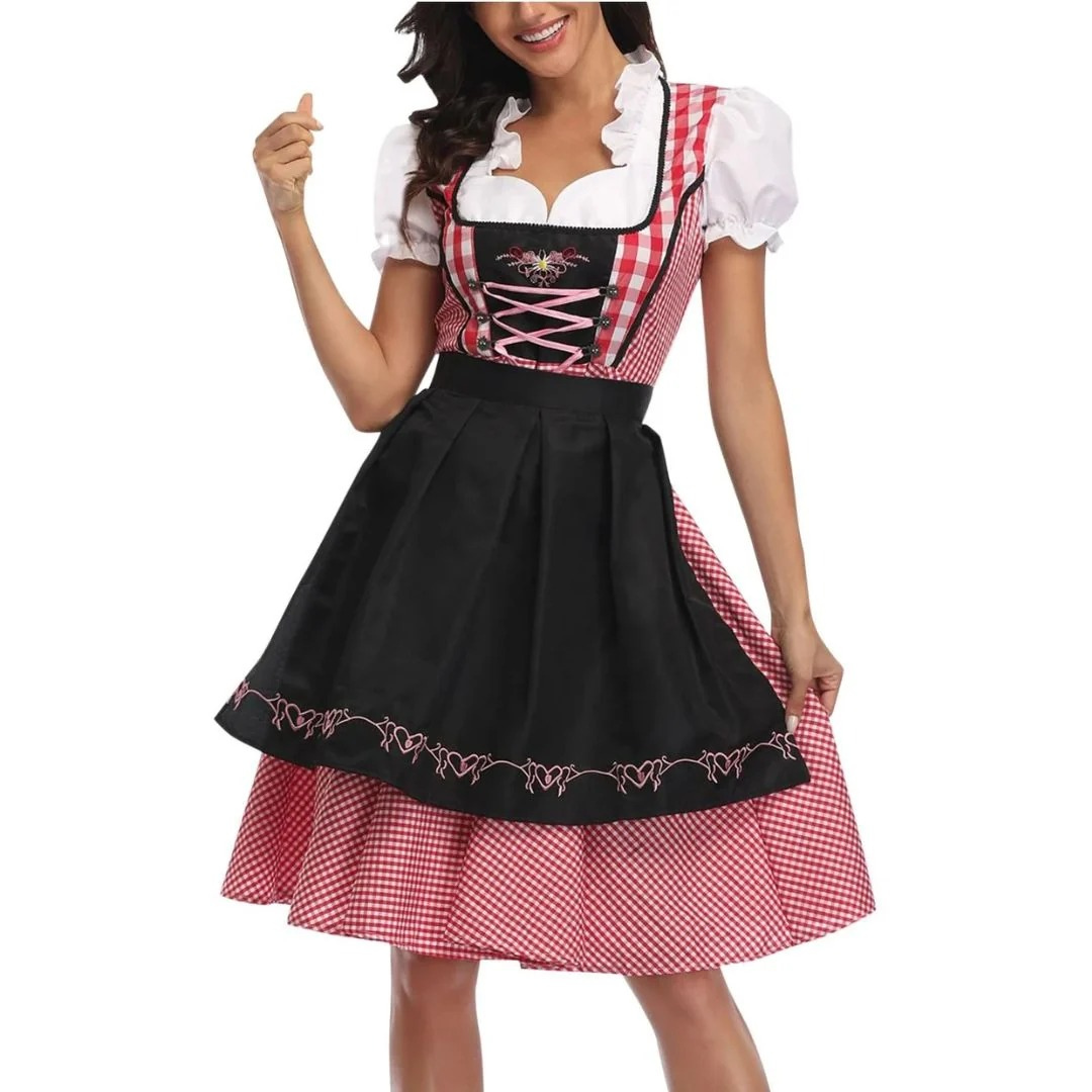 Közeli, elölnézeti kép: piros-fehér kockás dirndl fekete kötényel, rózsaszín fűzős míderrel és fodros fehér blúzzal, modellen. 1