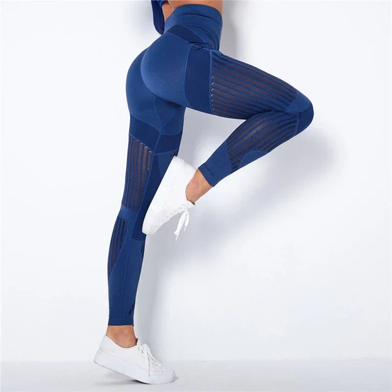 Kék leggings oldalról, felemelt lábú modellen, jól látszanak az áttört csíkos betétek 3